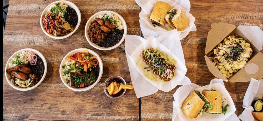 A spread of Mojo Grill bowls, sandwiches and Cuban specialties